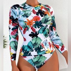 Two-Piece Tropical Long Sleeve Surfing Swimsuit * Size: X-Large (12) * Tropical Print * Multicolor * High Neck-Round Neck * Surfing Style Swimsuit * Long Sleeve * High Stretch * Swimsuit Fabric * 82% Polyester 18% Elastane * Machine Wash, Do No Dry Clean * Wash With Soft Detergent * Not Sheer Long Sleeve Floral Print Swimwear For Surfing, Casual White Swimwear For Surfing, White Long Sleeve Swimwear For Pool, Green Long Sleeve Bodysuit For Beach, Green Long Sleeve Bodysuit For The Beach, Long Sleeve Tropical Print Swimwear, Spring Tropical Printed Bodysuit, Long Sleeve Tropical Print Beachwear, Summer Long Sleeve Swimwear With Tropical Print