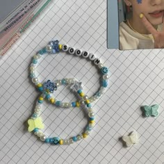 a child's photo and bracelets on a table with pencils next to it