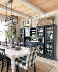 the dining room table is set with black and white checkered chairs, an old china cabinet