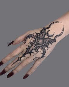 a woman's hand with an intricate tattoo design on it