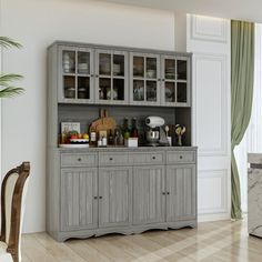 a dining room table and chairs in front of a gray china cabinet with glass doors