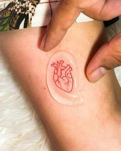 a person with a small tattoo on their leg that has a heart drawn on it