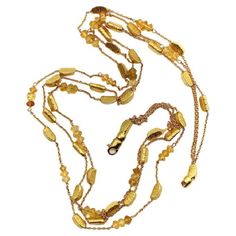 This 18k gold necklace consists of three strands of alternating gold bars and citrine briolette beads suspended between delicate gold chain. The shapes in this necklace are reminiscent of gold nuggets: the bars are moon-shaped wedges with a textured surface, while the citrine briollete beads are matched perfectly to the warm, buttery 18k gold, almost appearing to be made of gold as well. The two exterior strands contain both gold bars and citrine beads, while the center strand consists of only g Lingot D'or, 18k Gold Necklace, Citrine Beads, Gold Nugget, Gold Bar, Multi Strand Necklace, Strand Necklace, Multi Strand, Gold Chains