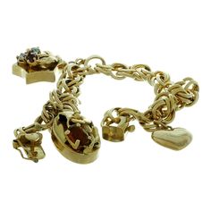 This classic vintage link bracelet is crafted in 14k yellow gold and features 3 charms - a heart charm (with some dents and fine scratches), a star charm prong-set with 3 faceted gemstones, and an oval charm prong-set with a yellow-orange citrine. Made in United States circa 1970s. Measurements: 0.35" (9mm) width, 8.25" (20.9cm) length. Pre-owned. Shows some normal signs of wear. Comes in an unbranded gift box. Gold Flower Bracelet, Orange Citrine, Vintage Charm Bracelet, Jaune Orange, Elsa Peretti, Wide Bracelet, Gold Charm Bracelet, Handcrafted Bracelets, Bezel Set Diamond