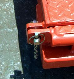 an orange piece of luggage sitting on top of a cement floor next to a parking meter