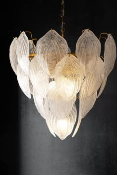 a chandelier hanging from the ceiling with white flowers on it's petals