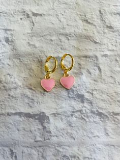 These cute and dainty gold-plated huggie earrings feature mini pink heart charms! Cute Hypoallergenic Huggie Earrings, Pink Drop Huggie Earrings, Cute Hypoallergenic Hoop Earrings, Pink Huggie Heart Earrings, Cute Huggie Hoop Earrings, Trendy Huggie Heart Earrings For Valentine's Day, Cute Pink Hoop Earrings For Valentine's Day, Trendy Huggie Earrings For Valentine's Day, Pink Hoop Earrings For Valentine's Day