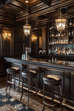 a bar with three stools in front of it and lights hanging from the ceiling