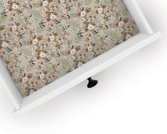 an open white box with floral wallpaper on it