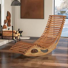 a wooden chaise lounge chair sitting on top of a hard wood floor next to a fireplace