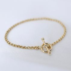 "14K GoldToggle Rolo Chain Bracelet - 14K Gold 2mm Rolo Chain Bracelet ★ 14K gold 2mm rolo chain ★ 14K gold toggle clasp ★ All components are 14K solid yellow gold The length includes the chain and the closure. Please measure your wrist before you place your order. ** How to choose a correct size of bracelet. 1. Measure your wrist below the wrist bone using a flexible tape measures, a string or a strip of paper. 2. If using a string or a strip of paper, mark length. Then, measure it with a ruler Elegant Gold Link Bracelet With Toggle Clasp, Classic Chain Bracelet With Toggle Clasp, Classic Gold Bracelet With Toggle Clasp, Yellow Gold Plated Bracelet With Toggle Clasp, Yellow Gold-plated Bracelet With Toggle Clasp, Elegant Yellow Gold Bracelet With Toggle Clasp, Classic Yellow Gold Chain Bracelet With Toggle Clasp, Classic Yellow Gold Bracelet With Toggle Clasp, Everyday Yellow Gold Chain Bracelet With Toggle Clasp