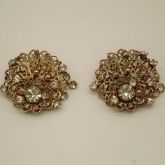 "This is a set of Rhinestone clip earrings. Features a brooch shape and a gold colored design, with a diamond in the center of each earring. Very beautifully detailed/designed. Would make a nice piece of jewelry to wear during the day.  Weight: 5 oz      Size: 1 1/2\" x 1 1'2\" V8840 If you are interested in purchasing more than one item from our shop and/or inquiring about reduced shipping rates--send us your zip code. Also, please contact us for International Shipping Rates." Vintage Jeweled Metal Clip-on Earrings, Formal Jeweled Metal Clip-on Earrings, Antique Gold Jeweled Earrings, Gold Jeweled Evening Clip-on Earrings, Gold Jeweled Clip-on Earrings For Formal Events, Gold Jeweled Clip-on Earrings For Formal Occasions, Gold Clip-on Crystal Jewelry, Gold Crystal Clip-on Jewelry, Crystal Clip-on Earrings For Evening