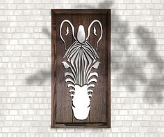 a wooden sign with an animal's head cut out of it on a brick wall