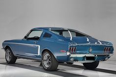 a blue mustang sitting on top of a checkered floor