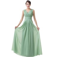 a woman in a long green dress standing on a white background with her hands on her hips