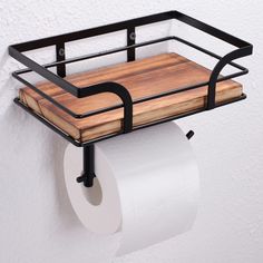 a wooden cutting board mounted to the side of a wall next to a roll of toilet paper