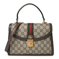 This is an authentic GUCCI GG Supreme Monogram Textured Dollar Calfskin Web Small Ophidia Padlock Top Handle Bag in Beige, Ebony and New Acero. This crossbody bag is crafted of GG supreme monogram coated canvas, with brown leather trim. The bag features an adjustable brown leather shoulder strap with gold hardware, a red and green web stripe detail down the center, and a matching gold Gucci GG logo on the crossover flap. The bag opens to a partitioned beige microfiber interior with zipper and patch pockets. Green Web, Gg Logo, Beige Fabric, Gucci Handbags, Handle Bag, Leather Trim, Leather Trims, Gold Hardware, Crossover