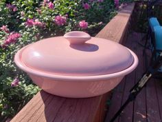 a pink casserole sitting on top of a wooden table