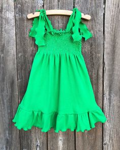 Green Smocked Dress This cute custom boutique green smocked dress would be perfect for St. Patricks Day or just a fun day out in the sun. Dress is a soft green knit, smocked, with shoulder ties to keep fitted. Your baby girl is guaranteed tons of compliments in this cute little dress. 100% Cotton St. Patricks Day Theme Wash Warm tumble dry low iron if needed Made To Order MADE IN USA Paint Splatter Dress, Bug Clothing, 2023 Crafts, Apple Dress, Cupcake Dress, St Pats, Cute Boutiques, Romper Outfit, Smocked Dress