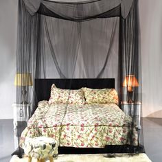 a bed with a canopy and flowers on the cover is shown in this bedroom setting