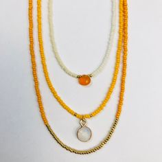 Qi: Orange Chakra Triple Beaded Necklace Set - One with band of small gold glass beads, one with small Carnelian teardrop and one with small Moonstone pendant — Sarah Crawford Handcrafted Gold Jewelry With Colorful Beads For Layering, Gold Beaded Necklaces With Tiny Beads For Healing, Gold Carnelian Beaded Necklaces For Healing, Gold Carnelian Beaded Necklaces In Bohemian Style, Gold Carnelian Beaded Necklace In Bohemian Style, White Teardrop Jewelry With Tiny Beads, Orange Healing Jewelry With Colorful Beads, Gold Teardrop Jewelry With Colorful Beads, Spiritual Yellow Jewelry With Gold Beads