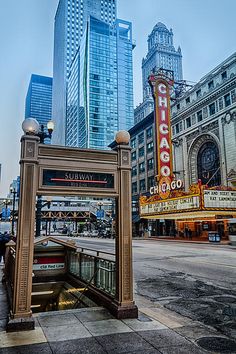 the chicago theater marquee is located in front of some tall buildings and skyscrapers