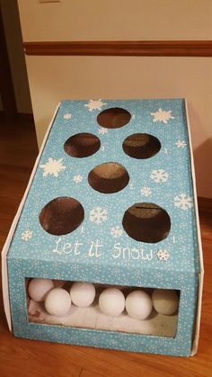 an open cardboard box with white and brown eggs in it that says let it snow