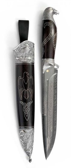 a knife with an eagle on it is next to a black and silver object that looks like a bird