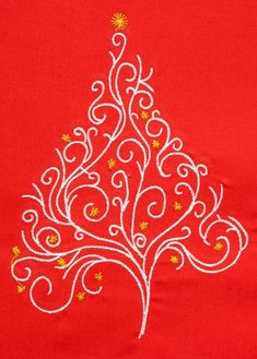 an embroidered christmas tree on red fabric with gold stars and swirls in the center