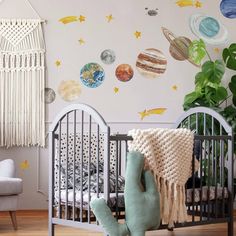 a baby's room with a crib and wall decals