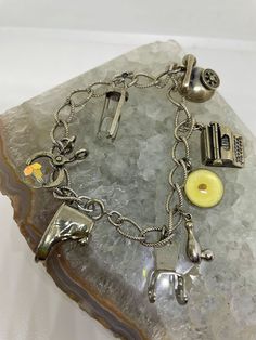 "Vintage sterling silver charm bracelet with eight sterling silver charms an hour glass, chair, shoe, type writer, mustard seed, scissors, bowling pin, and phone. Four charms are stamped silver and I believe the other four are also sterling silver. The mustard seed charm is inscribed on the back \"Amulet of faith, if ye have faith as a gram of mustard seed, nothing shall be impossible unto you, Sterling, Matt 1720.\" Several charms stamped \"Danecraft.\" Bracelet measures 6.5\" long." Cheap Vintage Charm Bracelet As Gift, Cheap Silver Bracelets With Vintage Charm, Antique Adjustable Charm Bracelet Gift, Antique Handmade Charm Bracelet For Gift, Handmade Antique Charm Bracelet As Gift, Handmade Antique Charm Bracelet For Gift, Vintage Adjustable Charm Bracelet With Lobster Clasp, Vintage Adjustable Charm Bracelet, Adjustable Vintage Nickel-free Charm Bracelet