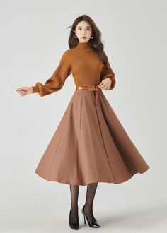 "Elevate your winter style with our brown wool swing midi skirt. The warm brown hue adds a touch of classic charm, and the premium wool fabric provides both style and warmth. The carefully crafted buttons create an elegant and dynamic look. This versatile midi skirt effortlessly transitions from day to night, making it a must-have choice for those who seek both fashion and coziness. DETAILS: * 30% wool, 30% fiber, 40% polyester * Fully satiny liner * Without pockets * Back zipper closure * Circl Long Beige Pleated Skirt For Fall, Beige Full Pleated Skirt For Fall, Brown Pleated Skirt For Winter Workwear, Beige Long Pleated Skirt For Fall, Brown Lined Pleated Skirt For Fall, Beige Flared Skirt For Winter, Brown Full Skirt For Workwear, Brown Full Skirt For Work, Wool Flared Skirt For Fall