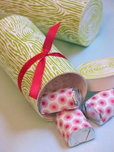 some candy wrapped in paper and tied with a red ribbon on a white table top