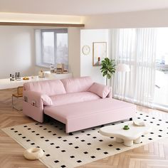 a pink couch sitting on top of a hard wood floor next to a white table