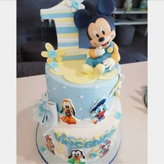 a blue and yellow mickey mouse 1st birthday cake