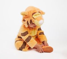 a small child in a tiger costume sitting on the floor