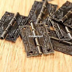 several antique style metal pieces on a wooden surface