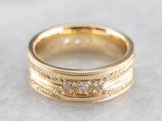 This engraved band is of a perfect heft and shape to feel soft and pleasant on the finger. It is both pretty and sophisticated, and it would be a great wedding or stacking band for a woman who wants a little extra sparkle but works with her hands. Metal: 18K Yellow Gold Gem: 12 Diamonds totaling .36 Carats, F in Color, VVS in Clarity Width of Band: 6.5 mm Height off Finger: 1.9 mm Ring Size: 6 Marks: "AA18K" Stamped on the inside band 14k Gold Bands With Diamond Accents, Luxury Stackable Rings With Thick Band For Wedding, Wedding Ring With Single Cut Diamonds And Thick Band, Fine Jewelry Yellow Gold Stackable Rings With Decorative Band, Yellow Gold Stackable Rings With Decorative Band, Yellow Gold Wedding Ring With Decorative Band, Wedding Diamond Jewelry With Milgrain, Yellow Gold Wedding Band With Decorative Detail, Wedding Diamond Milgrain Jewelry