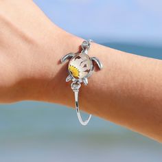 Exquisite and refined, the nautically-inspired Pressed Daisy Sea Turtle Bracelet adds a touch of elegance to any outfit. This unique bracelet is the perfect reminder of warmer weather and happy beach memories for your favorite beach lover.  Details:  Eco-friendly Alloy with Silver Finish Real Daisy in Resin Oval Size: 65mm (length) x 55mm (width) Sunshine on your neck, the ocean in your ears. Discover GoBeachy jewelry - where summer never fades. Dive into sun-kissed sparkle, where quality meets Nature-inspired Adjustable Jewelry Gift For Her, Adjustable Nature-inspired Jewelry Gift For Her, Nature-inspired Adjustable Jewelry As Gift For Her, Adjustable Nature-inspired Jewelry As Gift For Her, Adjustable Beachy Bracelet As Gift, Adjustable Beachy Bracelets For Gifts, Adjustable Beachy Bracelets As Gift, Bohemian Flower Charm Jewelry For Beach, Handmade Charm Bracelet For Beach