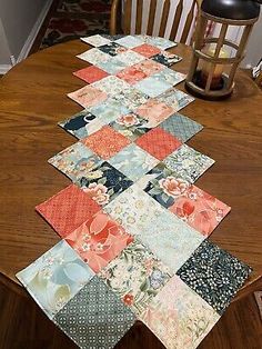 a wooden table topped with lots of different colored patchwork