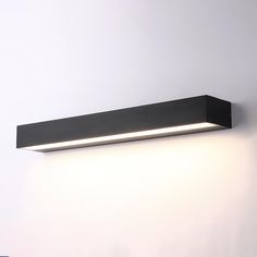 a wall mounted light on the side of a white wall