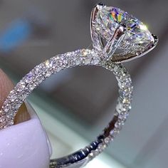 a close up of a diamond ring on someone's finger