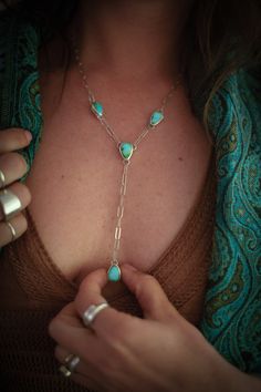 This one-of-a-kind Lariat necklace features a Y-shaped design that consists of four hand-fabricated turquoise pendant pieces. Each stone is Sonoran Mountain Turquoise, which has a beautiful complexion with variations of blues and greens. An elegant paperclip chain links all the pendants together. The piece is finished with a high polish to make it shine! MATERIALS Sonoran Mountain Turquoise Sterling Silver DIMENSIONSNecklace measures 20" with a 3.5" drop. Note: the paperclip chain allows you to wear the necklace at any length 20" or less! Simply clip at any length you'd like! Artisan Turquoise Adjustable Lariat Necklace, Artisan Turquoise Lariat Necklace Adjustable, Artisan Adjustable Turquoise Lariat Necklace, Turquoise Dangle Necklace, Turquoise Lariat Jewelry With Adjustable Chain, Sterling Silver Lariat Turquoise Necklace Gift, Artisan Turquoise Lariat Necklace As Gift, Bohemian Lariat Necklace With Gemstone, Adjustable Artisan Turquoise Necklace