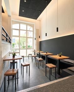 an empty restaurant with wooden benches and tables