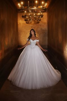 a woman in a white wedding dress posing for the camera