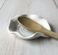 a wooden spoon sitting on top of a white bowl