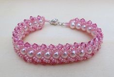 "The elegant color of pink combine with an accent of AB rose pink makes the bracelet a sweet delicate with a little bit of dazzle for your wrist. This bracelet is hand stitch using colored Czech glass pearls, swarovski bicone crystal and embellished the edge with Japanese seed beads to make a chain. The bead work is done in flat spiral style. I use the fireline beading thread to stitch and silver tone magnetic clasp to finished it off and for an easy wear. The bracelet measures 7 1/4\" and will Pink Jubilee Bracelet With Round Beads, Pink Jubilee Beaded Bracelet, Handmade Pink Crystal Round Bracelet, Handmade Pink Crystal Bracelet For Wedding, Pink Jubilee Bracelet For Party, Pink Crystal Bracelet With Round Beads For Party, Handmade Pink Crystal Elegant Bracelet, Handmade Elegant Pink Crystal Bracelet, Adjustable Pink Crystal Bracelet For Wedding