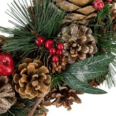 pine cones, berries and evergreen leaves are arranged on a white background for christmas decorations