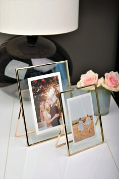 three frames are sitting on a table next to flowers and a vase with roses in it