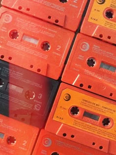 many orange cassettes are stacked on top of each other in order to be sold